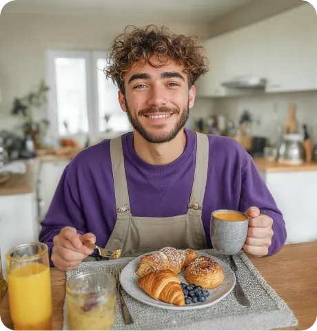 Smiling man having breakfast in a kitchen
