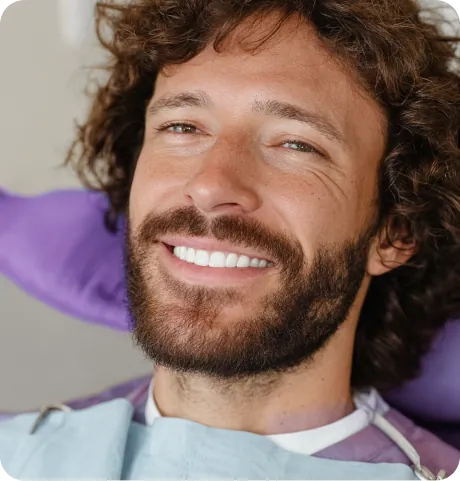 Happy man showing white teeth at the dentist
